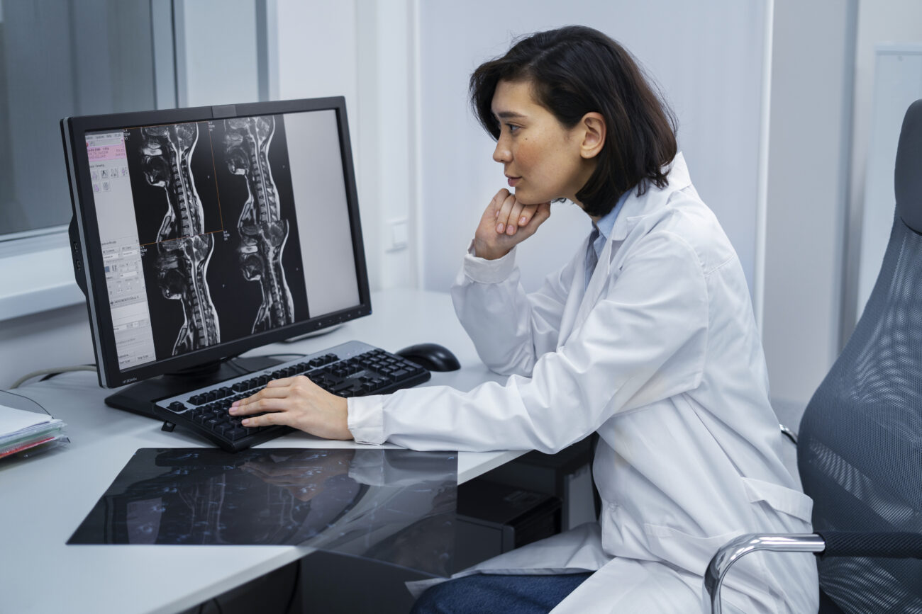 Doctor reviewing radiology scans on a computer screen as part of an online training course for international diagnostic practice.