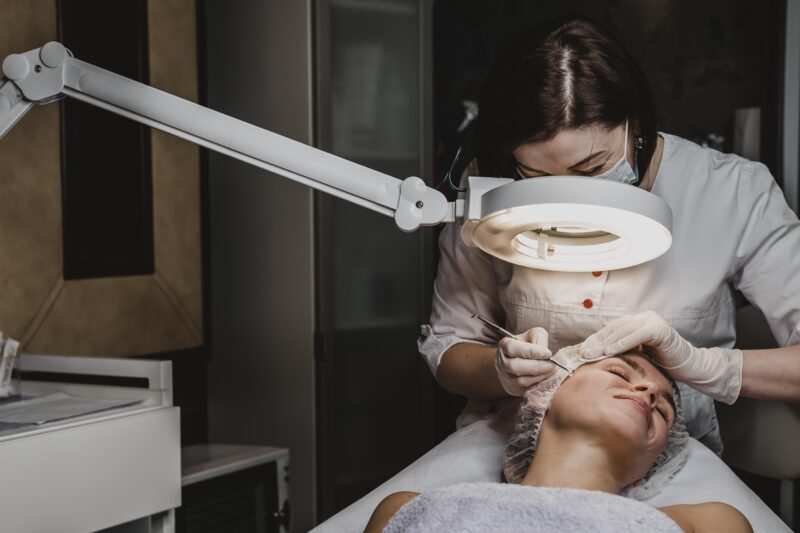 Doctor performing a cosmetic dermatology procedure in a clinical setting, representing the shift from medical dermatology to aesthetic practice